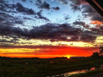 Scenic view of dramatic sky over landscape during sunset