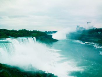 Scenic view of waterfall against sky