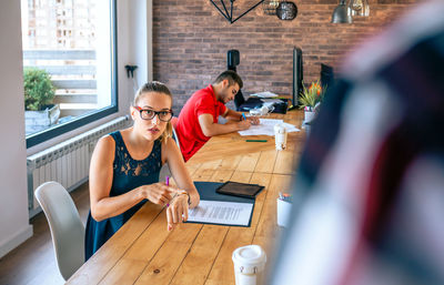 Angry female manager discussing with man for coming late to office