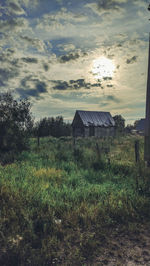 Abandoned house on field against sky