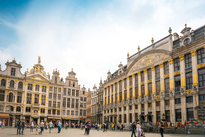 People in front of historic buildings at grand place square