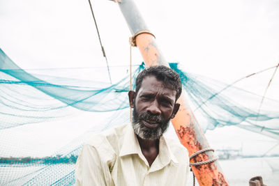 Low angle view portrait of man holding camera