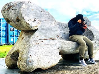 Side view of woman photographing sculpture