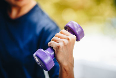 Close-up of man holding dumbbell