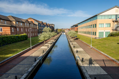 View of swimming pool by buildings against sky