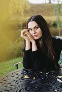 Portrait of young woman sitting on field