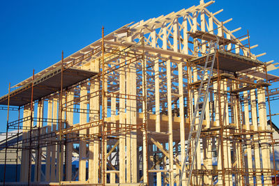 Low angle view of incomplete building against clear sky at construction site