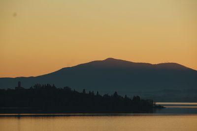 Scenic view of lake against orange sky