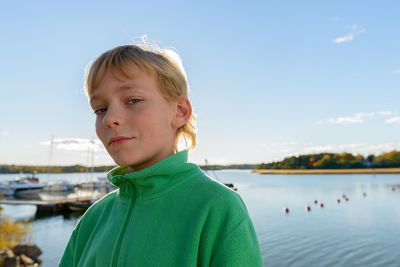 Portrait of boy looking at sea against sky