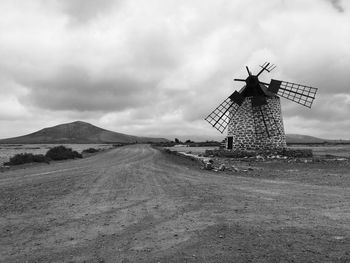 Traditional windmill on field against sky