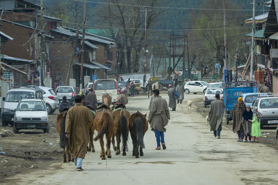 Group of people walking on street in city