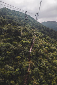 Overhead cable car over mountains against sky