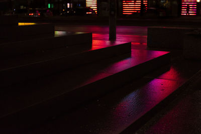 Empty benches in illuminated building at night