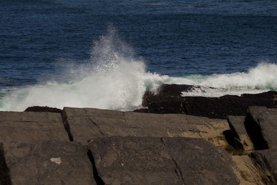 Waves splashing on sea against sky