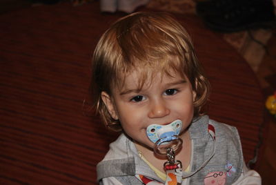 Portrait of cute boy with pacifier in mouth