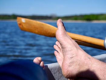 Midsection of man hand on sea against sky