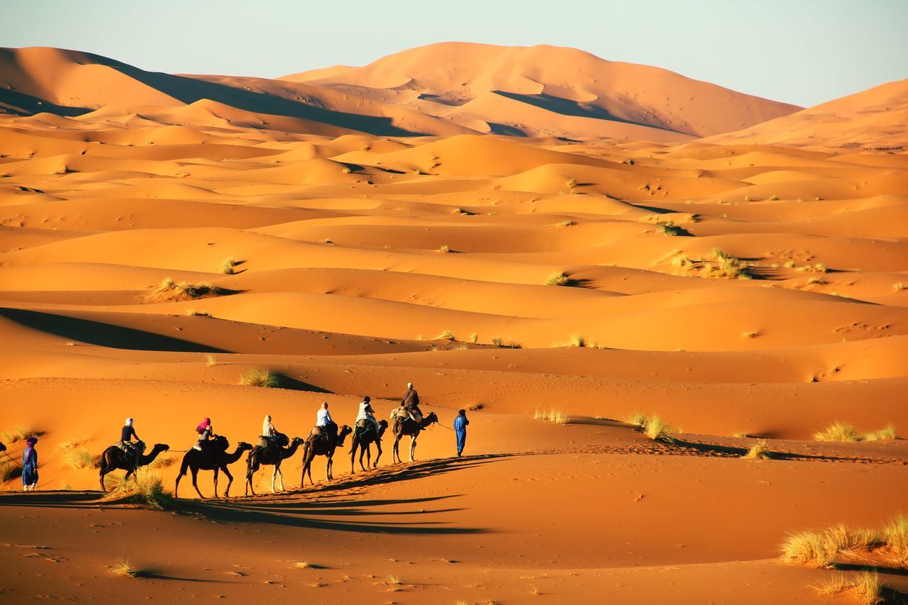 PEOPLE ON SAND DUNE IN DESERT