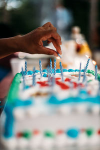 Lighting candles on a birthday cake.