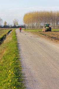 Road amidst field against sky