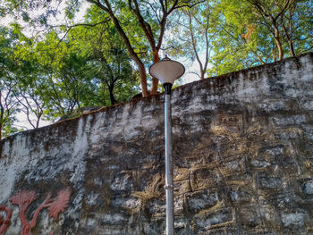 Low angle view of street light against wall