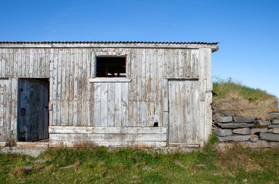 Old wooden structure on field against sky