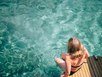 High angle view of girl sitting in swimming pool