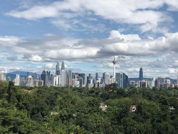 Skyscrapers in city against cloudy sky