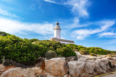 Lighthouse by sea against sky