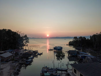 High angle view of boats moored at harbor during sunset