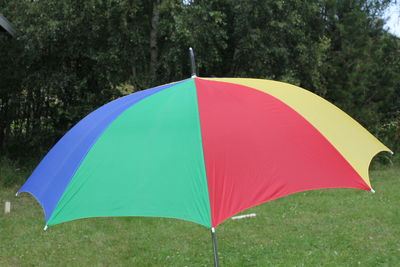 Close-up of colorful umbrella on grassy field