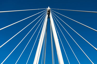 Low angle view of suspension bridge against clear blue sky