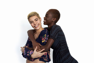 Lesbian couple embracing against white background