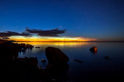 Scenic view of lake against sky at night