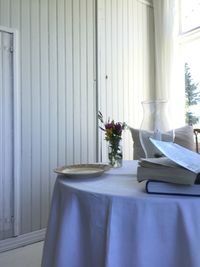 Flower vase on table against window at summer house 