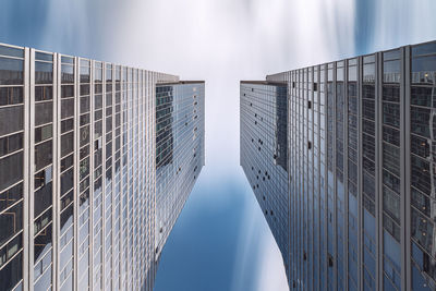 Look up  view of modern office buildings against mooving clouds