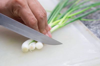 Cropped image of person preparing food on cutting board