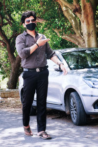 Full length of man standing by car