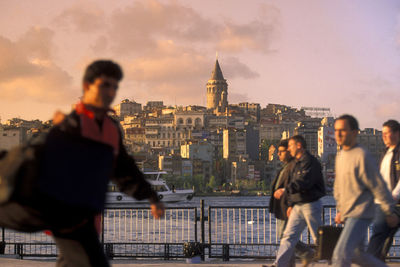 Man and buildings against sky during sunset