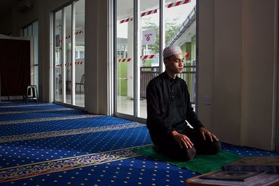 Side view of young man praying to god