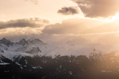 Scenic view of snowcapped mountains against sky during sunset