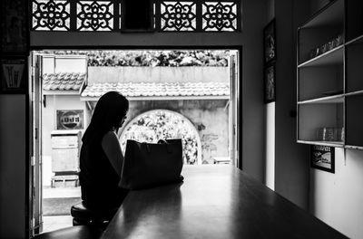 Rear view of woman sitting at home