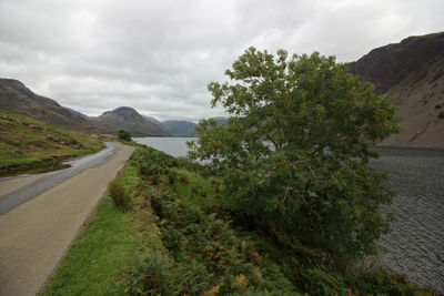 Scenic view of road by mountains against sky