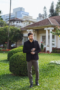 Portrait of young man standing against building