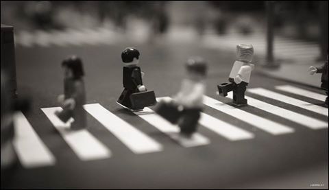 Group of people crossing toy car on road