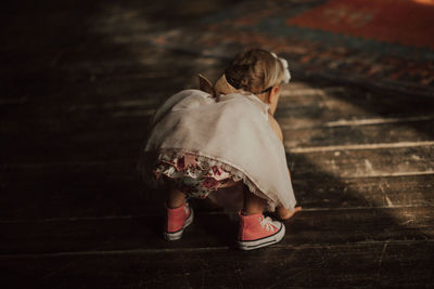 Rear view of baby girl bending on floor