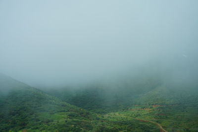 Scenic view of landscape against sky during foggy weather