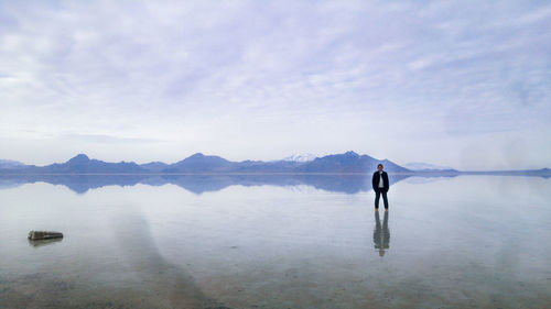 Full length of man standing in lake against sky