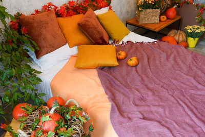 Home autumn decor. cozy fall bedroom interior bed with orange pillows and pumpkins, autumn 