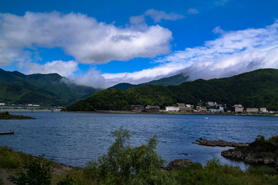 Scenic view of lake by buildings against sky