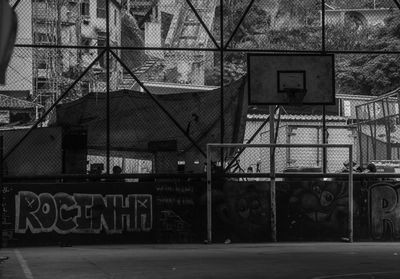 Text on fence against building in city